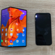 The Mate X next to a Huawei P20 (far left), an iPhone XS (second from right), and the Samsung Galaxy S10+ (far right).